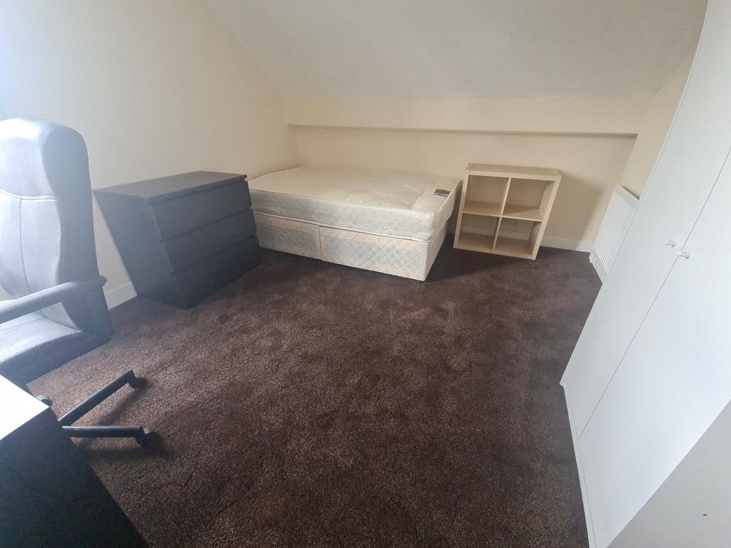 A simple, small bathroom with a toilet, showcas...