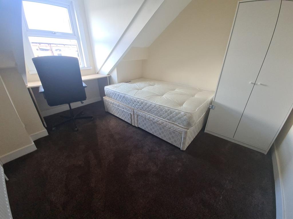 A cozy single bedroom featuring a clean and wel...