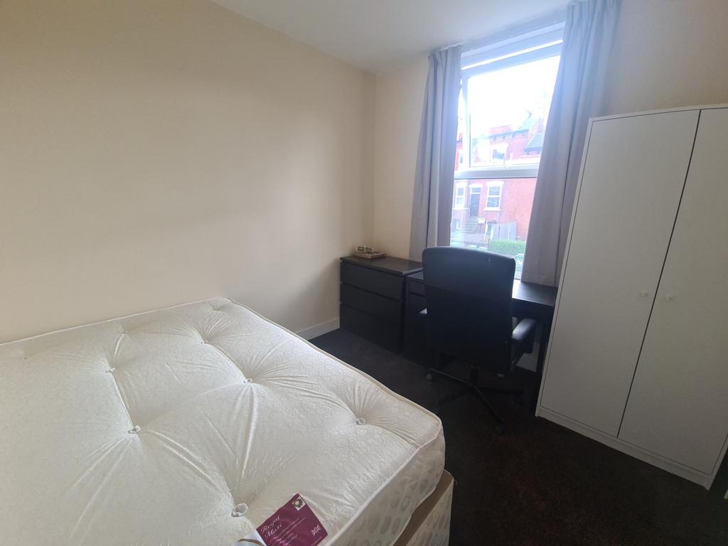 A spacious master bedroom featuring a large bed...