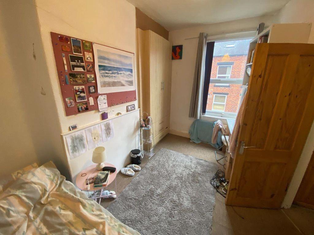 A cozy bedroom featuring a single bed, a spacio...