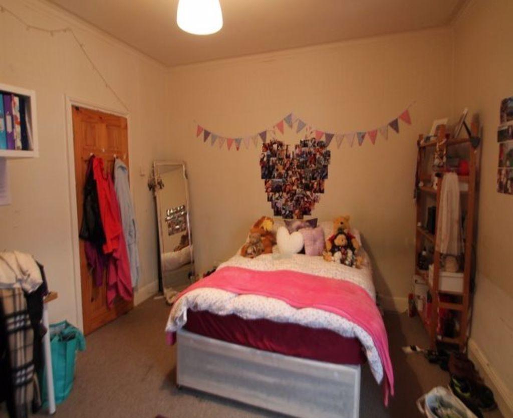 A cozy master bedroom featuring a large bed dec...