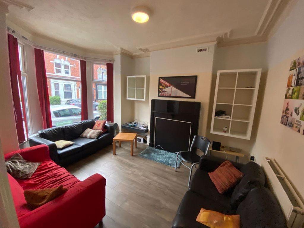 Spacious and well-lit living room featuring com...