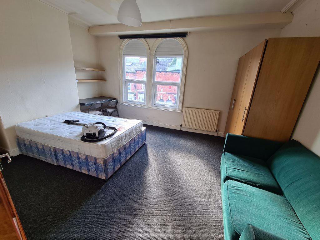 A cozy bedroom with a single bed, a window prov...