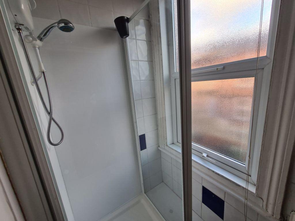 A clean and functional bathroom suite with a sh...