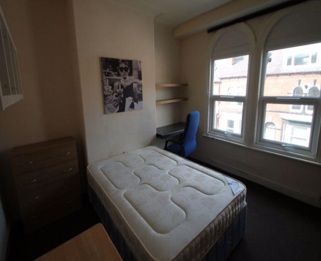 A tidy and well-lit small bedroom featuring a s...