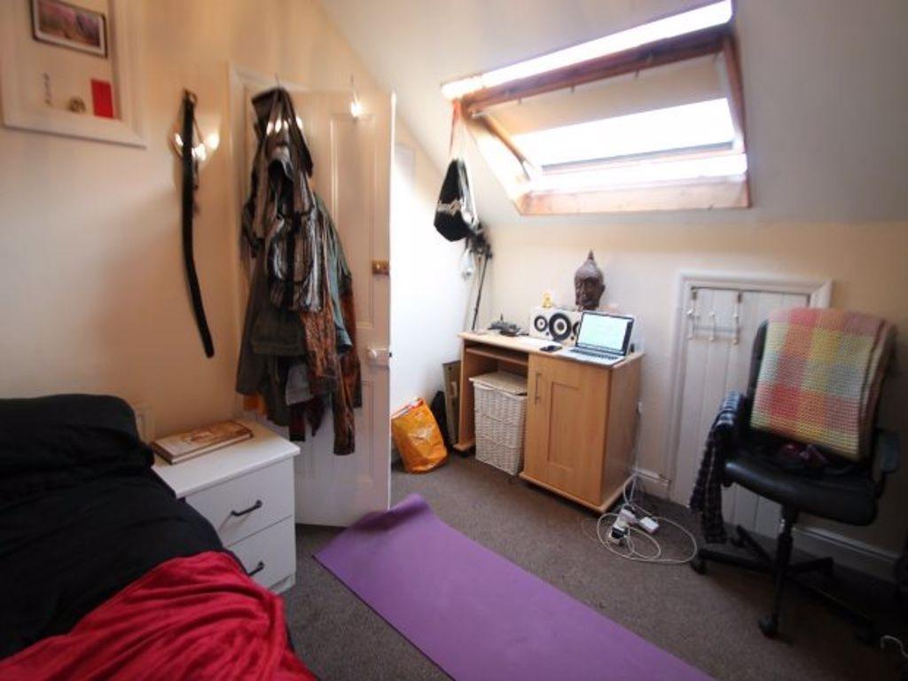 A cozy single bedroom featuring practical furni...