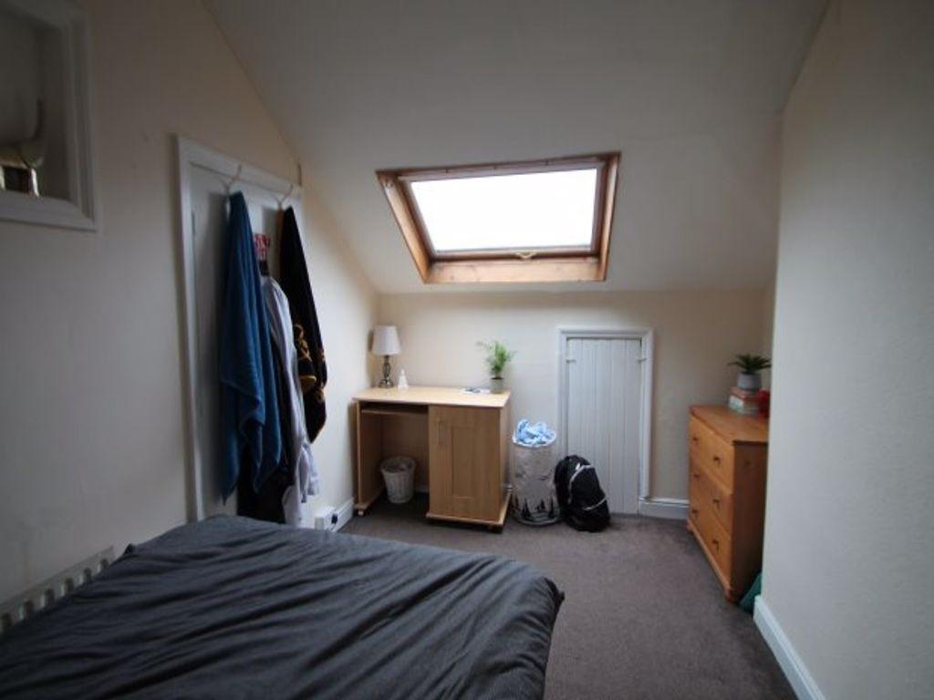 A well-lit bedroom with a skylight window, feat...