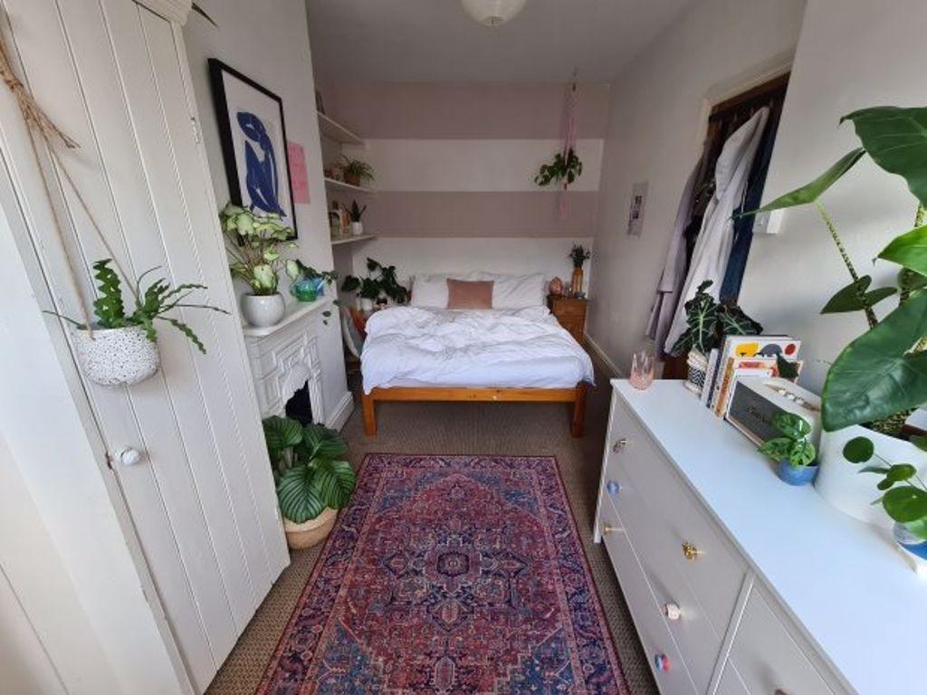 A bright and welcoming bedroom featuring a cozy...