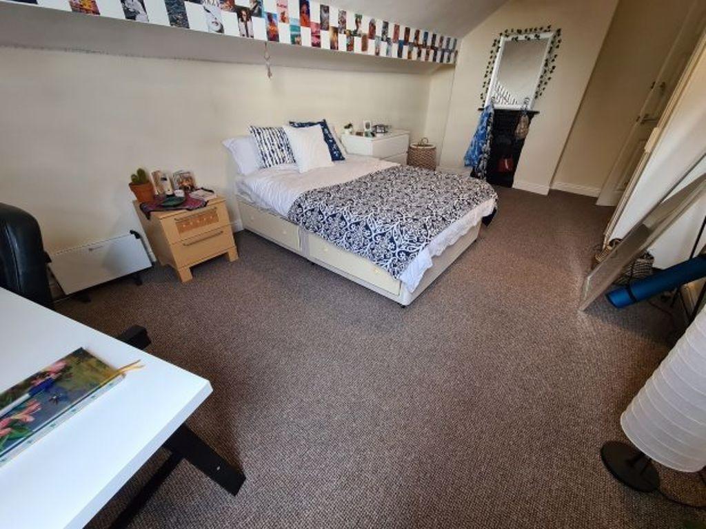 A spacious and well-maintained bedroom featurin...