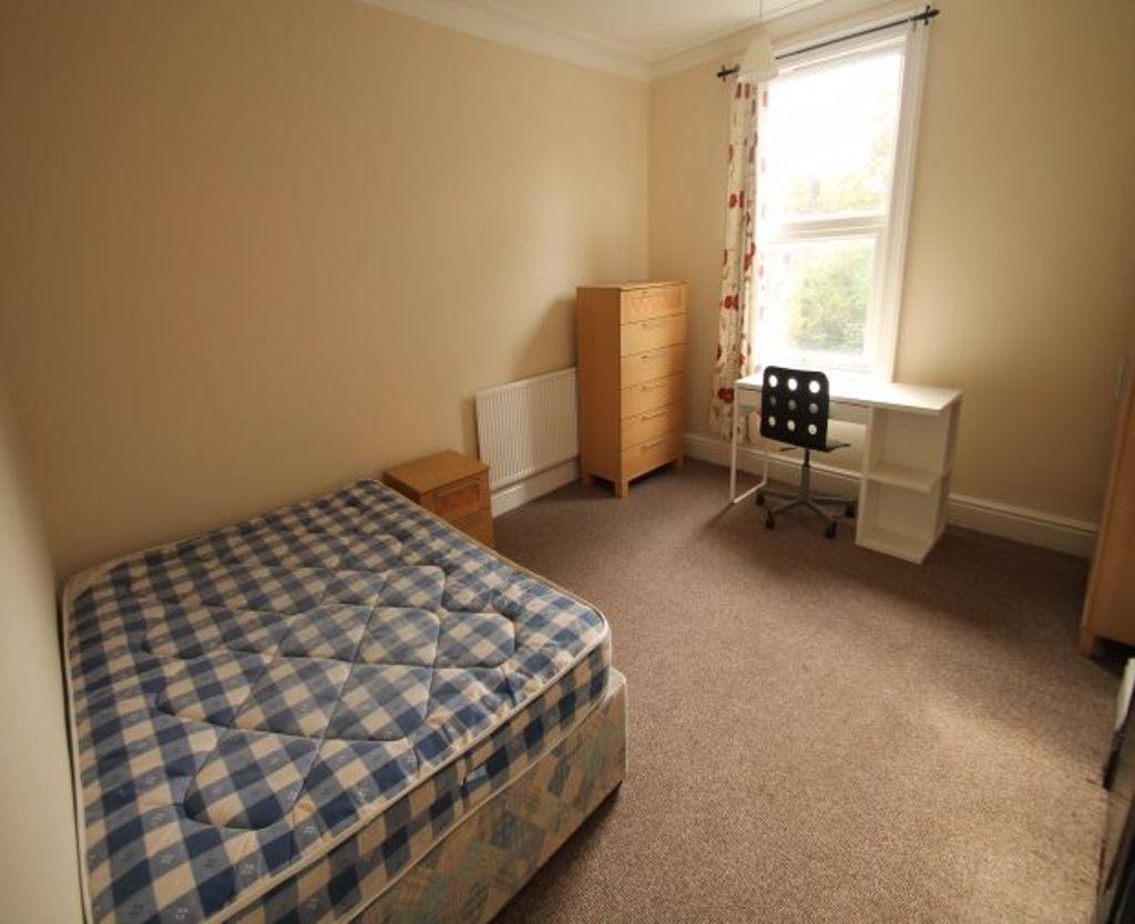 A bright and tidy bedroom featuring a single be...