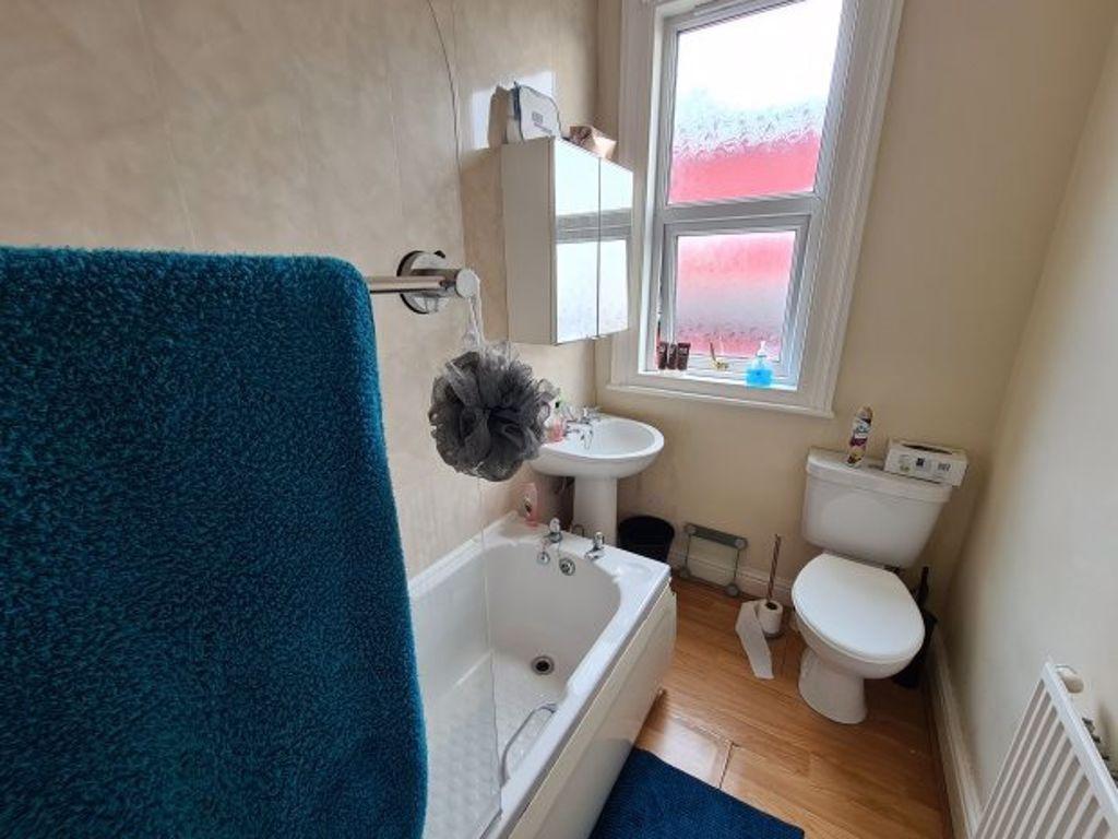 Bright and clean bathroom with a large bathtub,...