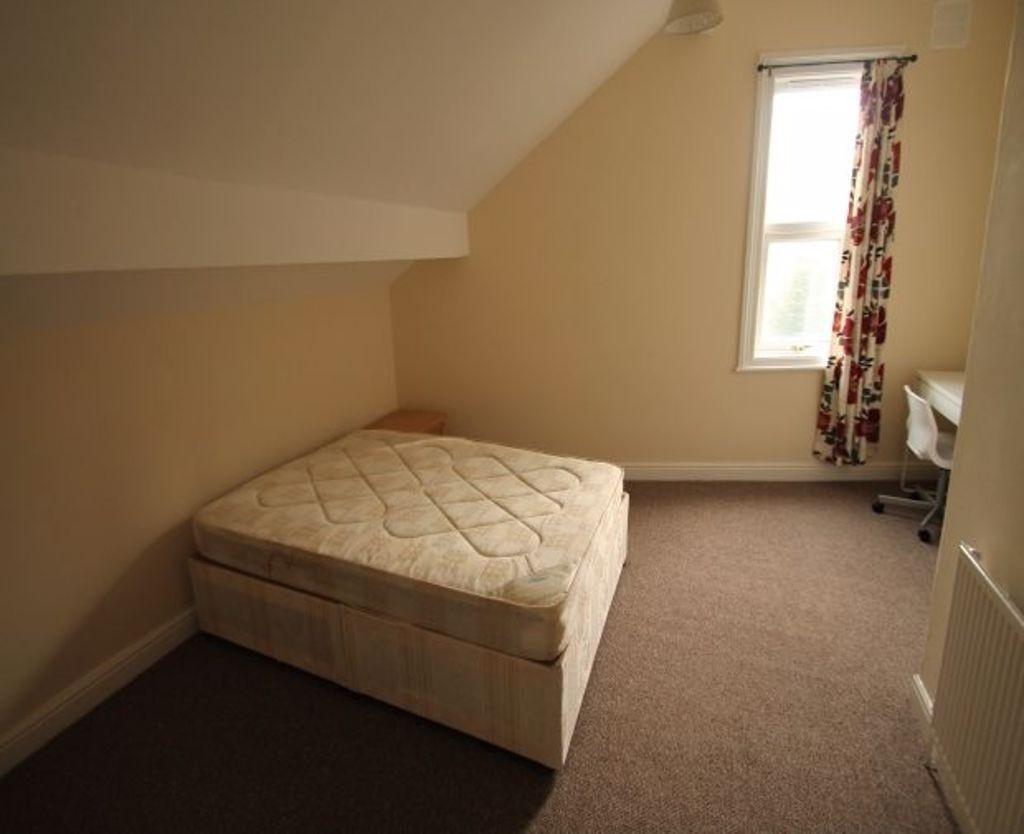 A cozy single bedroom featuring a comfortable b...
