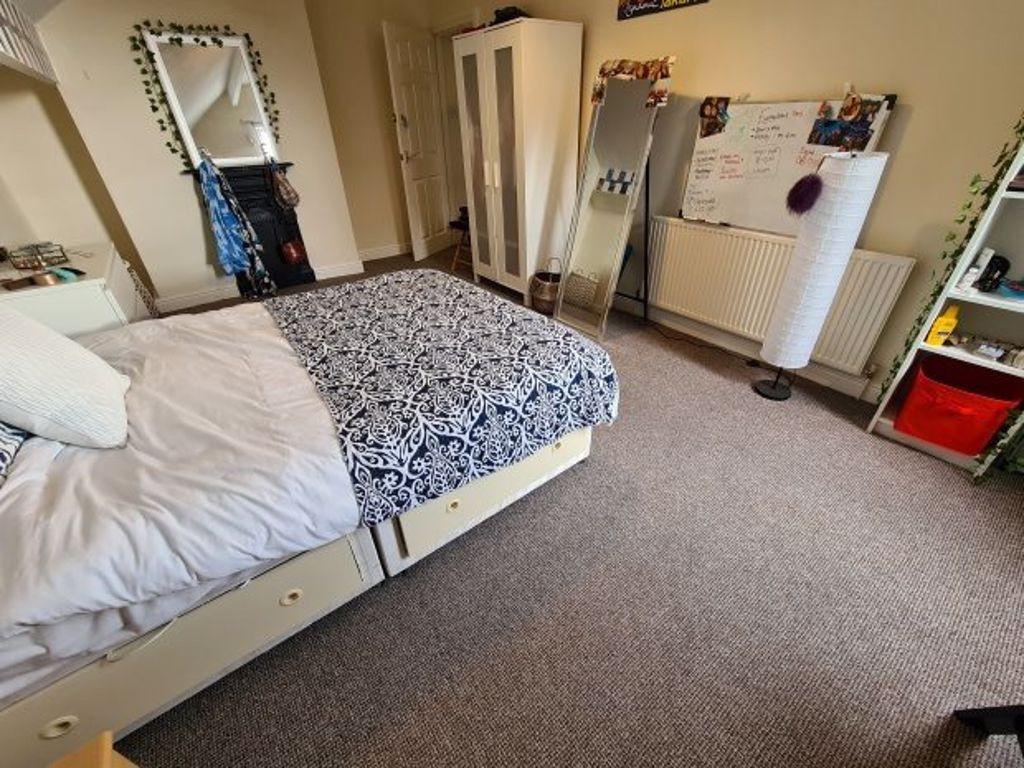 A cozy student bedroom featuring a comfortable ...
