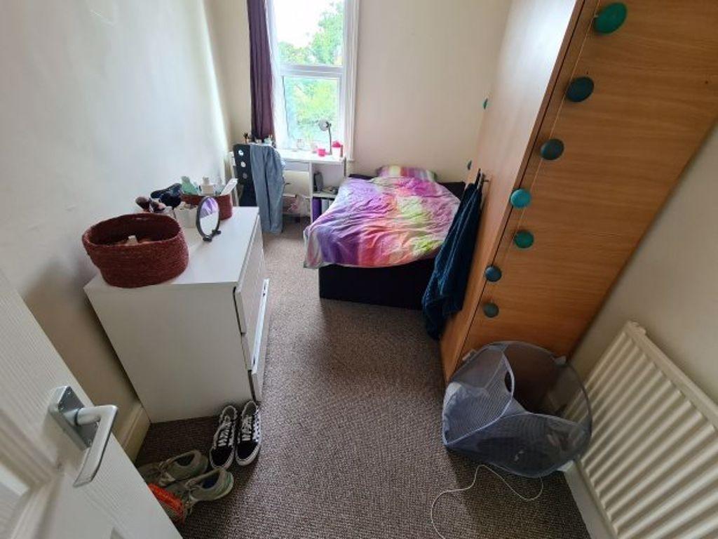 A cozy student bedroom featuring a single bed w...