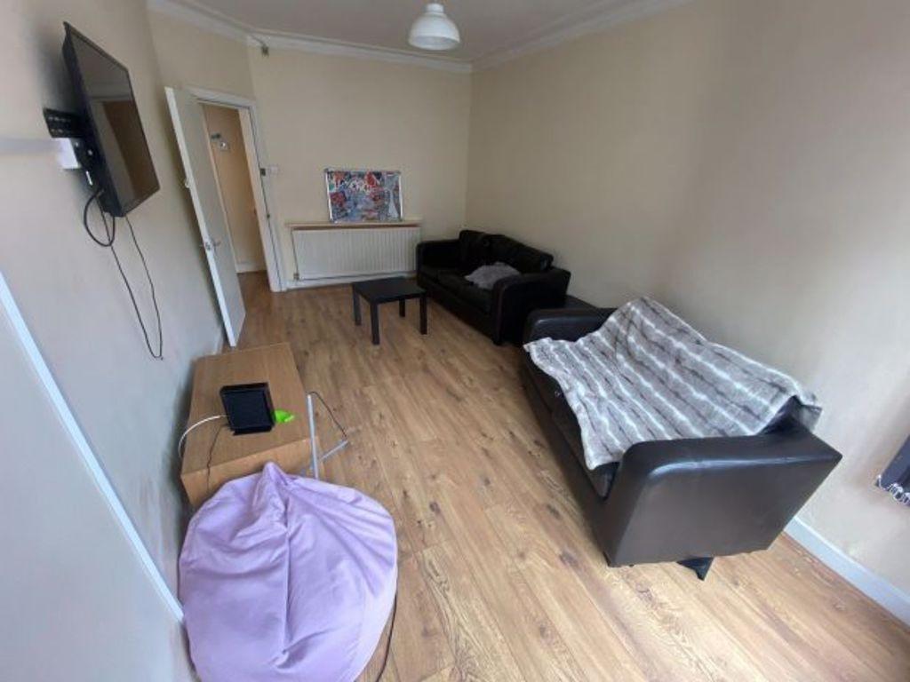 A cozy bedroom featuring a single bed, a small ...