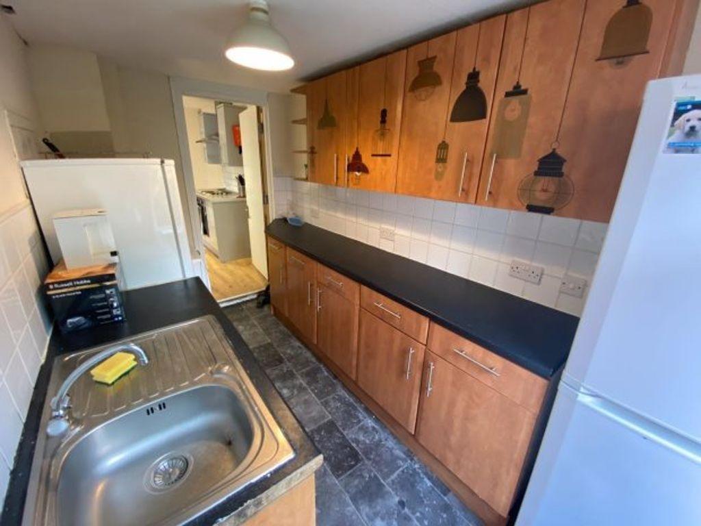 A well-maintained kitchen with wooden cabinets,...