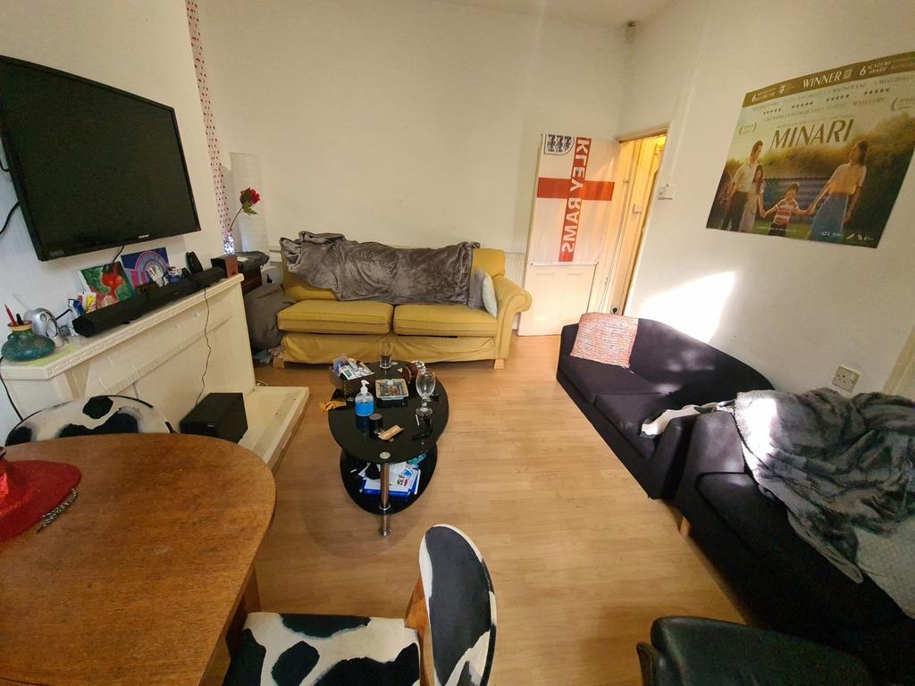 A cozy living room featuring a black sofa, a ye...