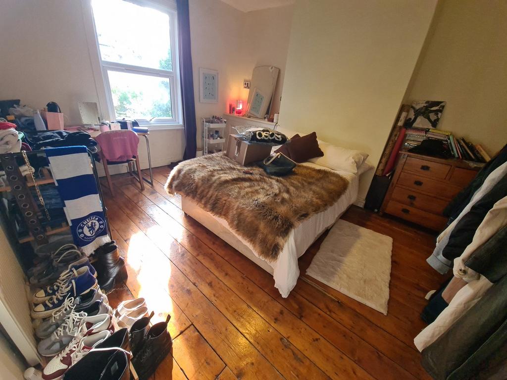 A spacious master bedroom featuring a large bed...