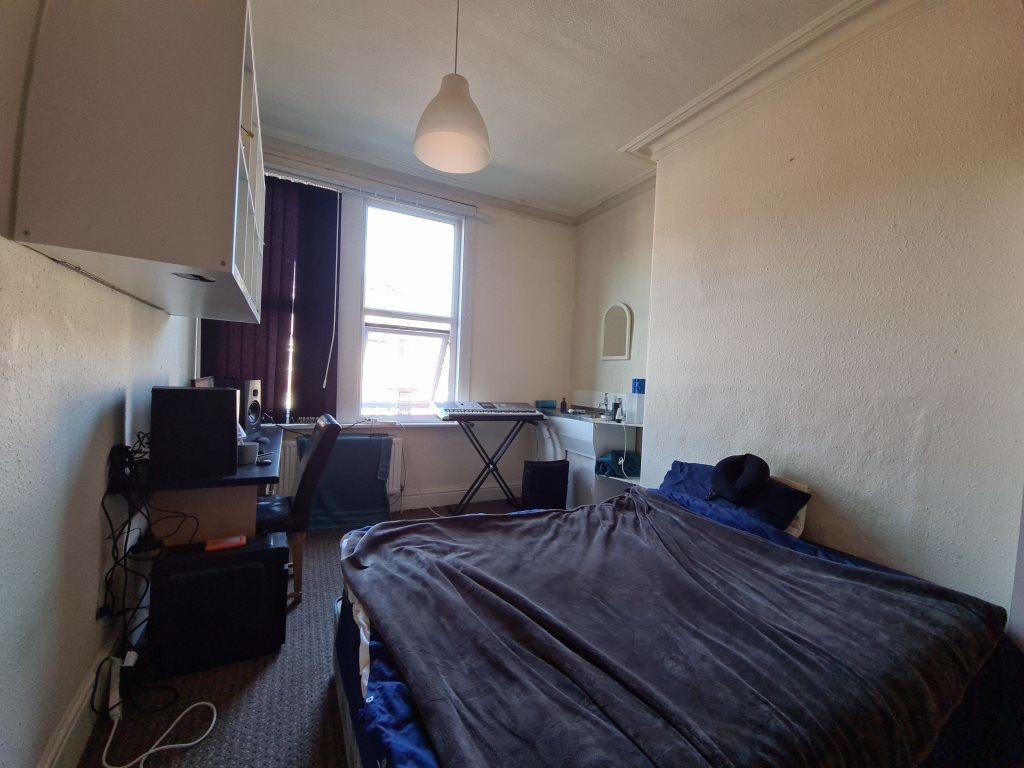 A modest bedroom featuring a single bed and a w...