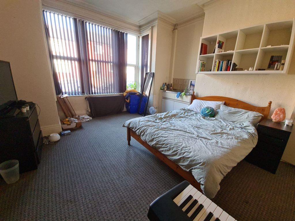 A bright and tidy bedroom featuring a large dou...
