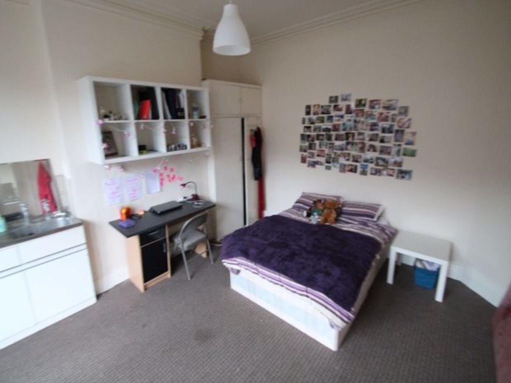 A cozy and tidy single bedroom featuring a comf...
