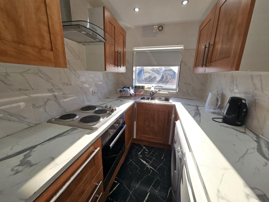 A modern kitchen featuring marble countertops, ...