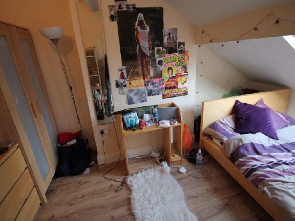 A cozy bedroom featuring a single bed with purp...