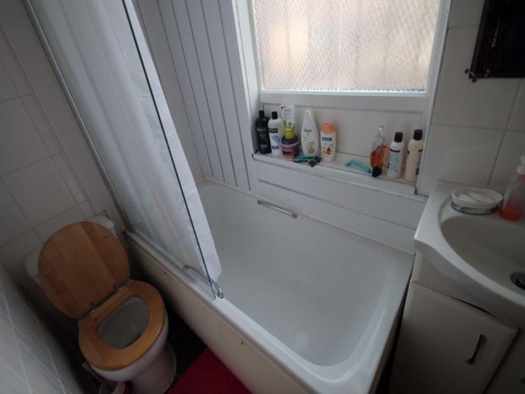 A bright, clean bathroom with a bathtub, sink, ...