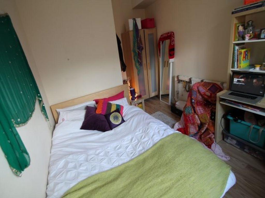 A well-lit double bedroom featuring a cozy bed ...