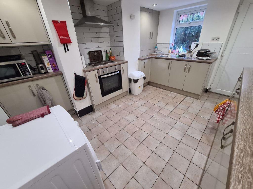A clean and well-lit kitchen area with ample sp...