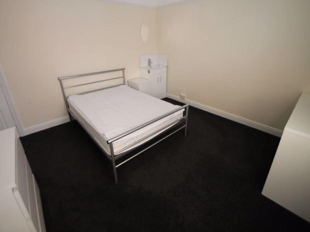 A spacious master bedroom with a comfortable do...