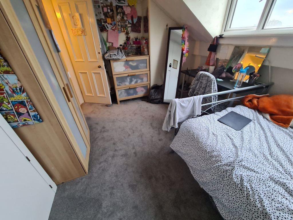 A cozy bedroom with a bed, some storage units, ...
