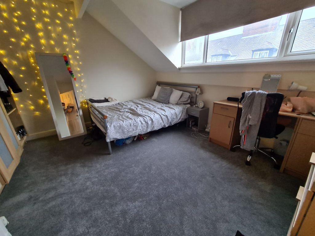 A bright and cozy bedroom featuring a comfortab...