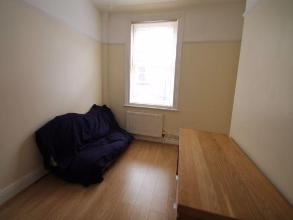 A small, tidy room with a window providing natu...