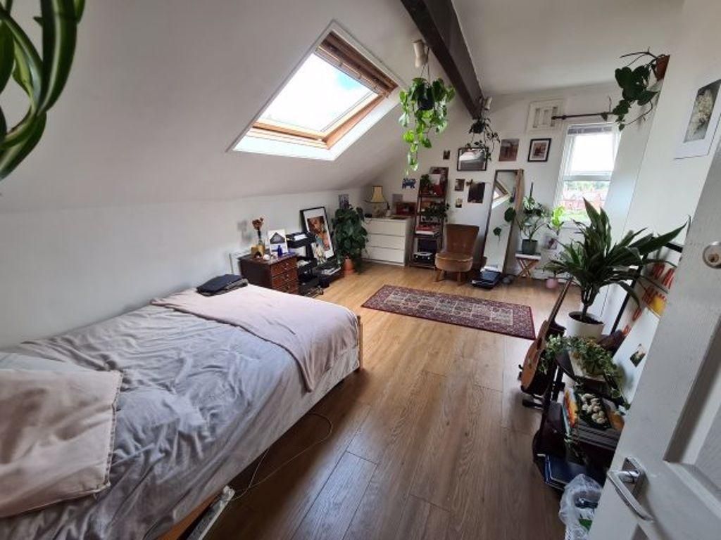 A bright and cozy bedroom featuring a large bed...