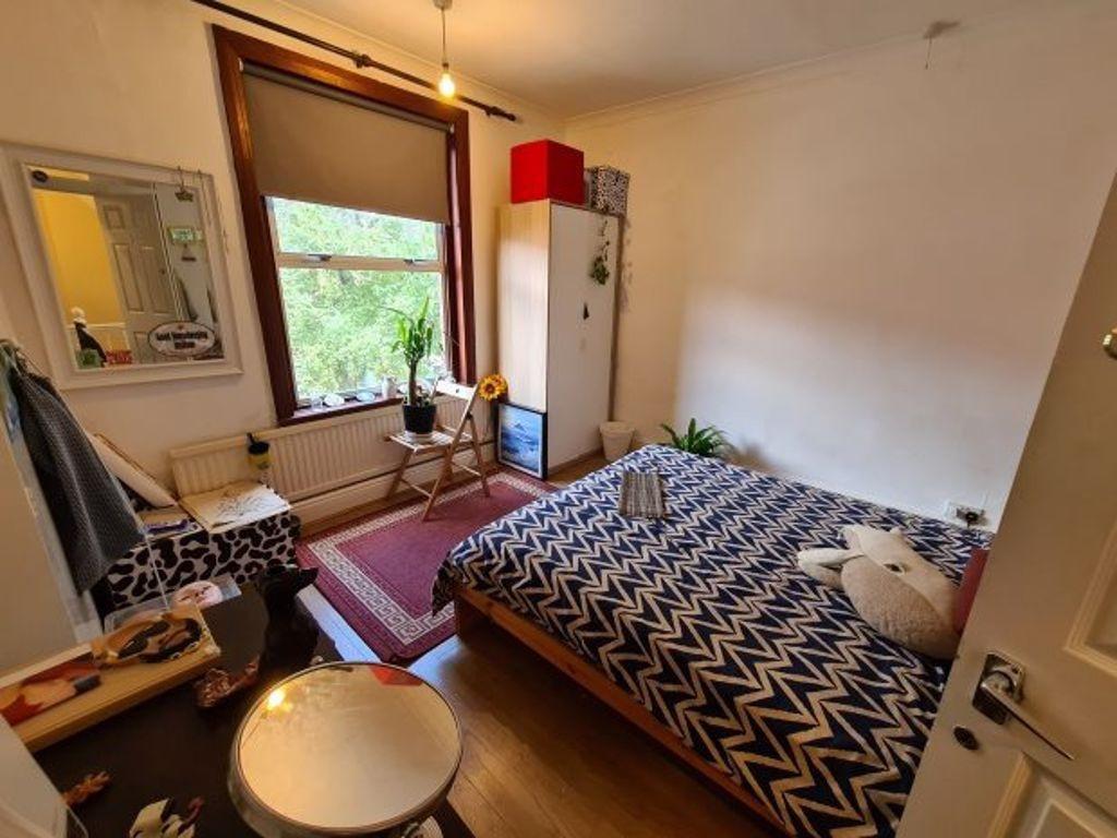 A cozy single bedroom featuring a neatly made b...