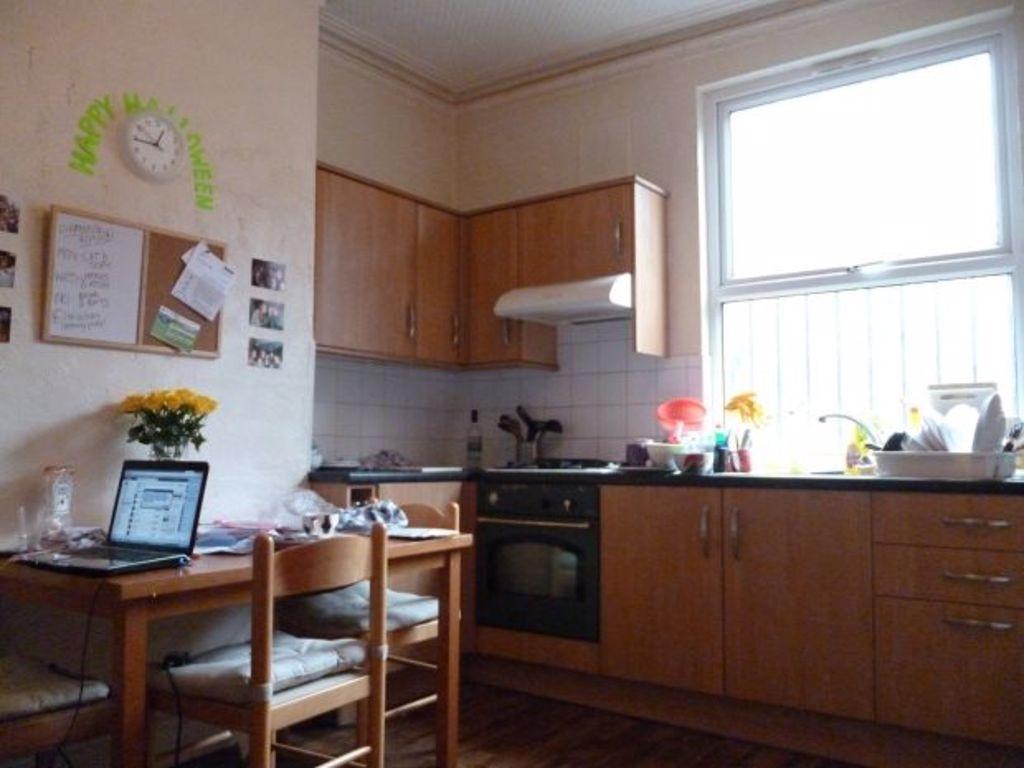 A well-lit, clean kitchen with wooden cabinets,...