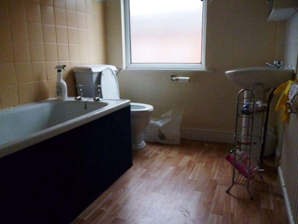 A compact bathroom featuring a bathtub, toilet,...