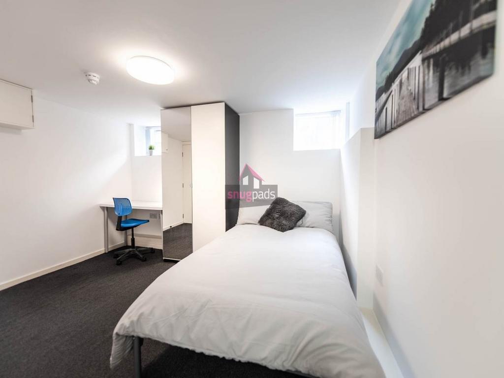 A bright and tidy bedroom featuring a comfortab...