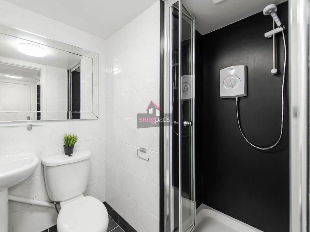 Modern white bathroom with a glazed shower encl...