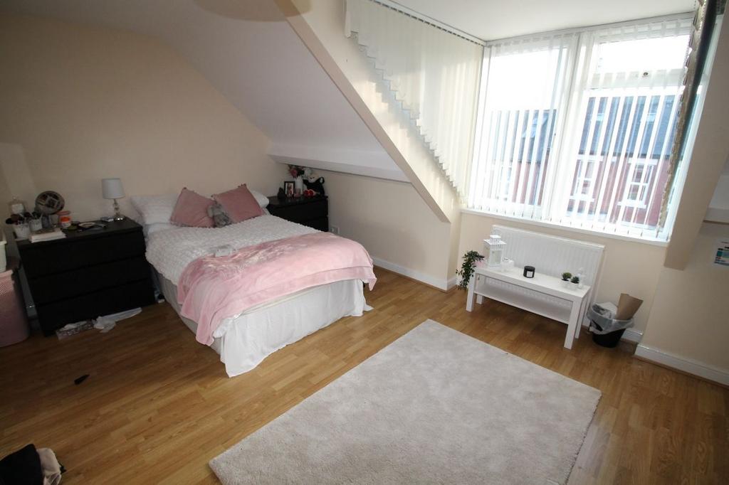 A spacious, well-lit master bedroom featuring a...