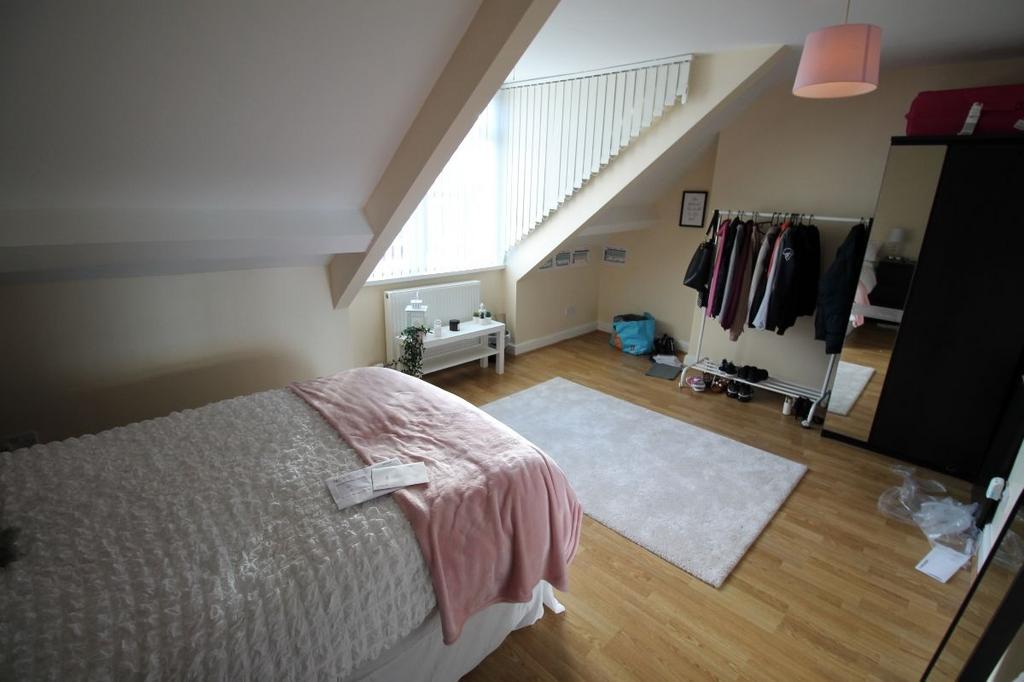 A bright and cozy bedroom featuring a large bed...