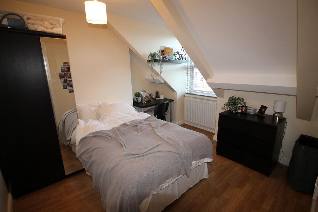 A spacious, well-lit master bedroom featuring a...