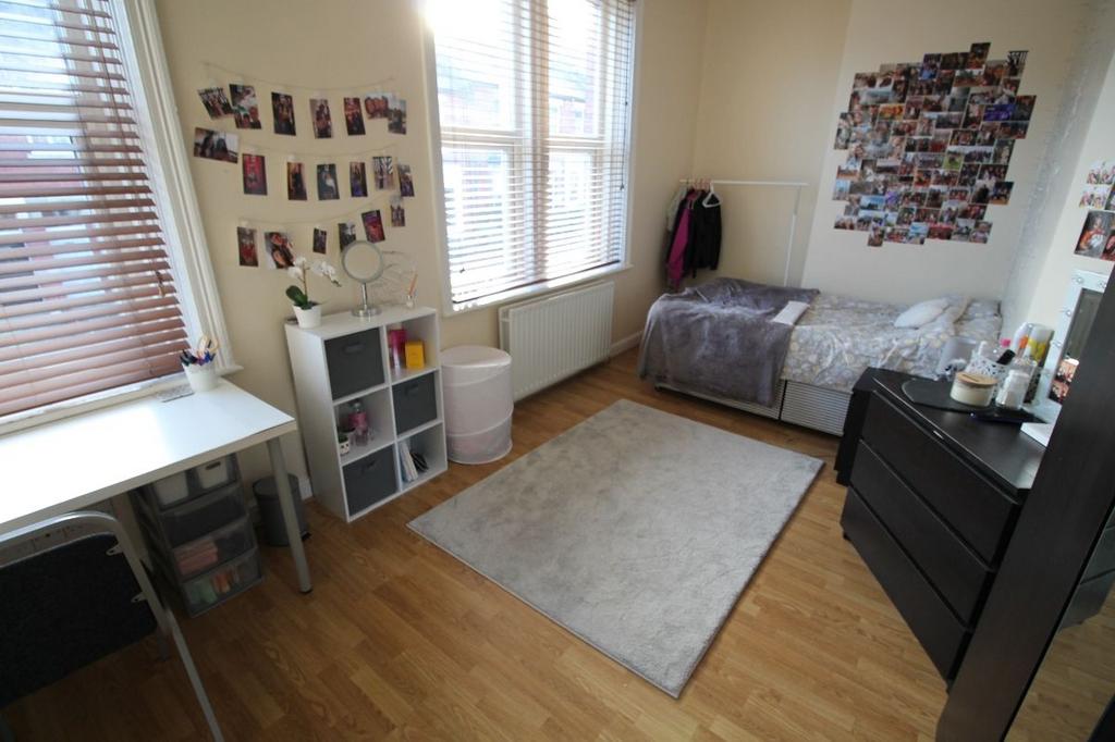 A cozy, well-lit bedroom featuring a single bed...