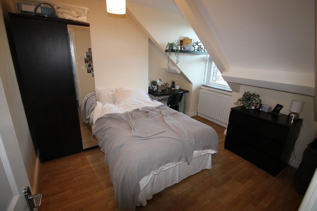 A cozy and well-maintained bedroom featuring a ...