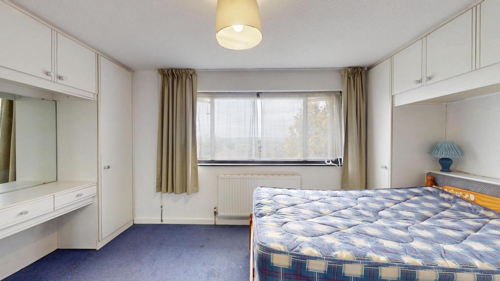 A well-lit bedroom featuring a large window tha...