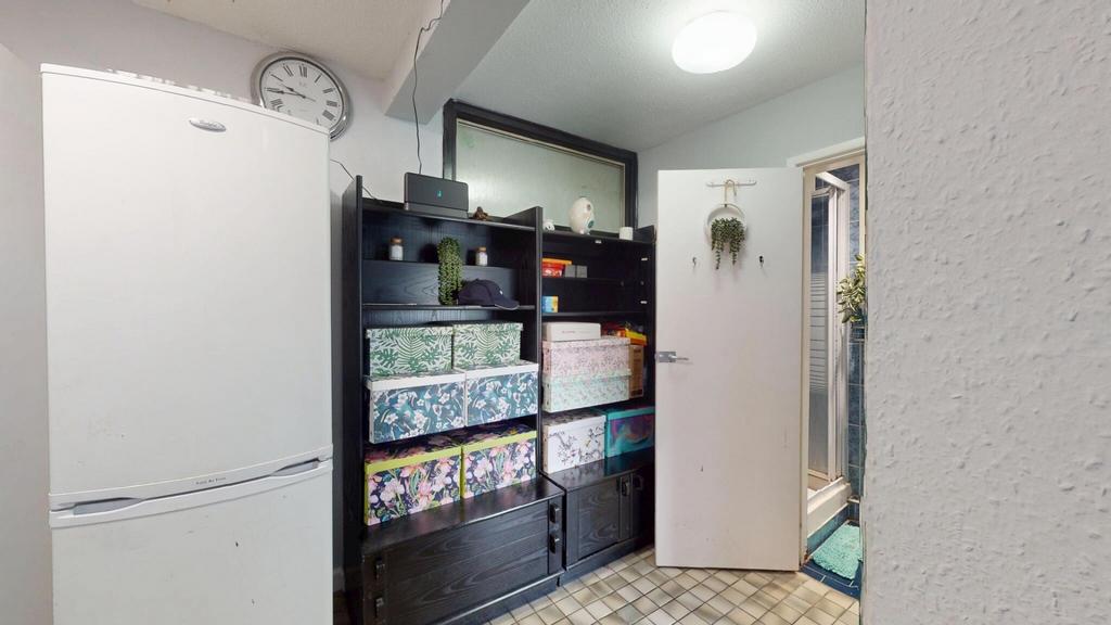 A compact kitchen area featuring shelves and st...