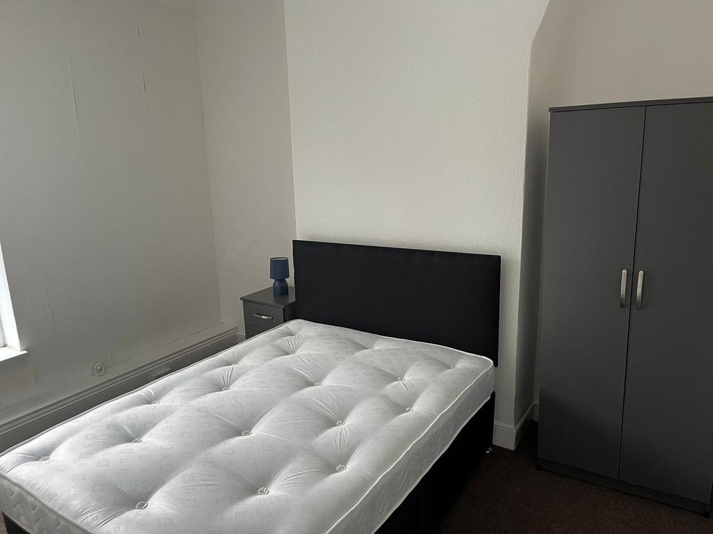 A tidy and functional single bedroom featuring ...