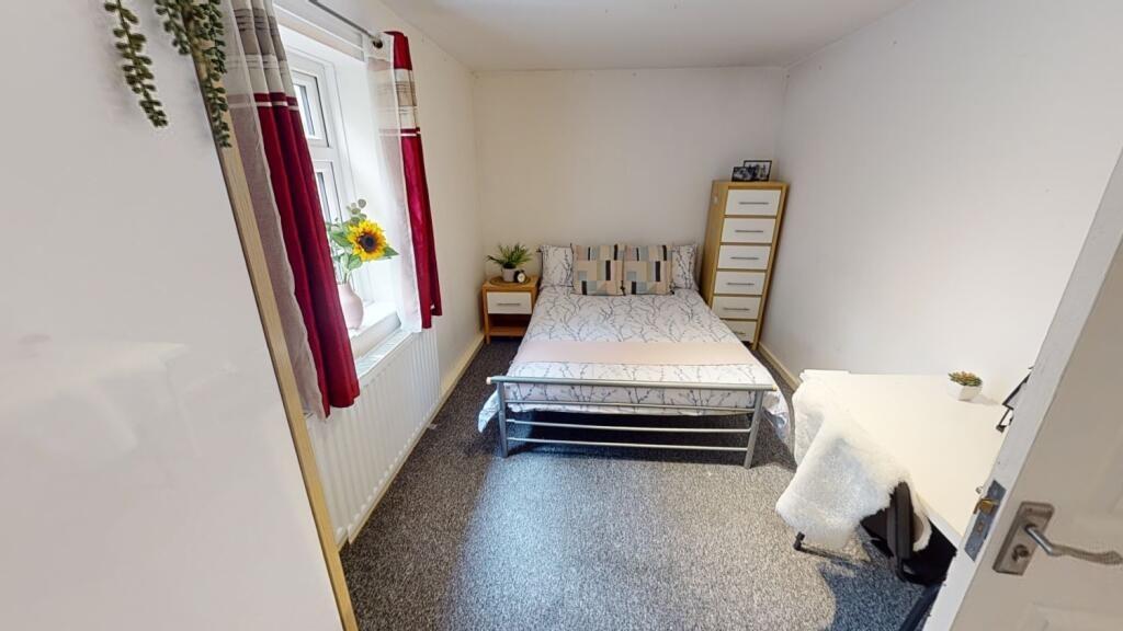 A bright and tidy single bedroom featuring a co...