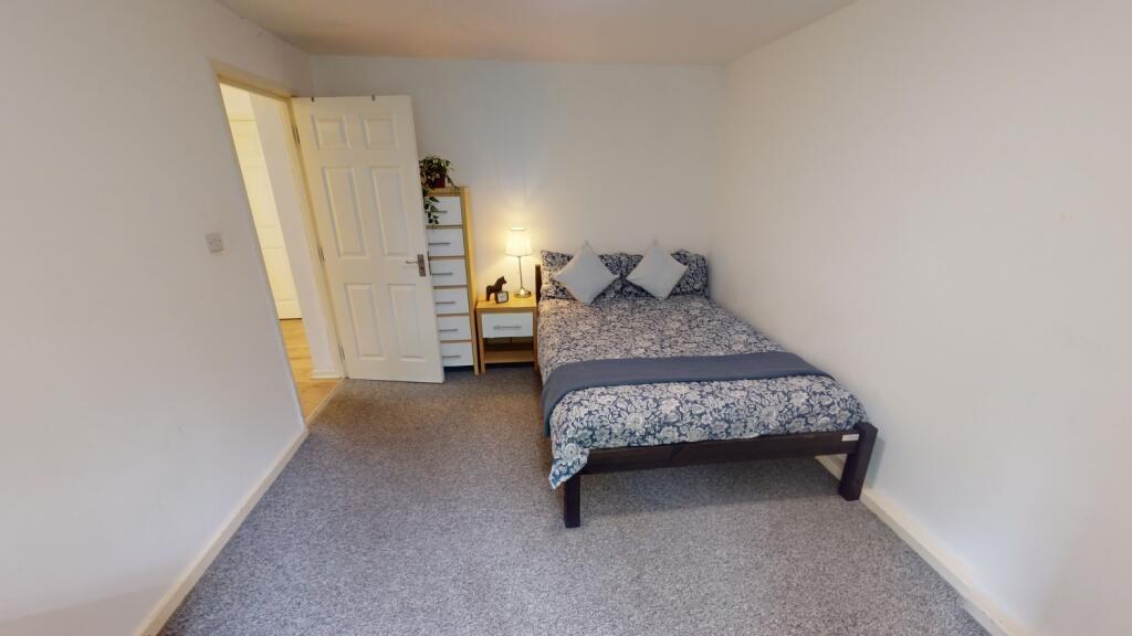 A well-kept bedroom featuring a double bed with...